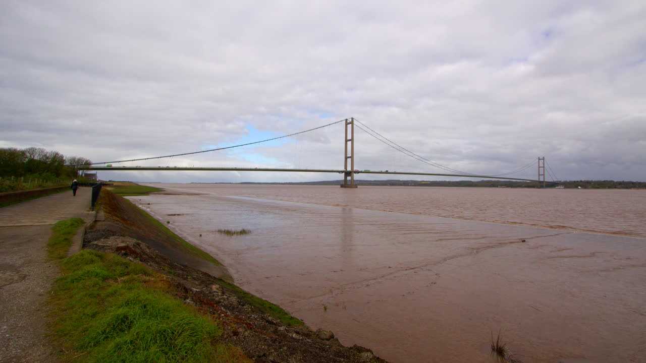 extra wide shot of the Humber bridge showing exposed mud flats on the Humber estuary with footpath