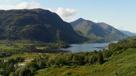 Drohnenaufnahme-Des-Glenfinnan-Viadukts-Mit-Wasser-Und-Bergen-Im-Hintergrund