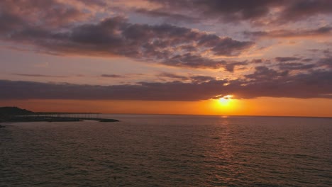 Dawn-on-Garraf-horizon,-with-Ginesta-port-in-background,-Catalonia