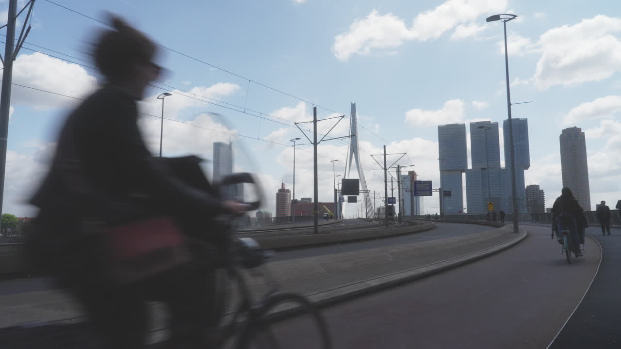 Rotterdam Cityscape: Tram, Cyclists, and Modern Architecture on Erasmus Bridge