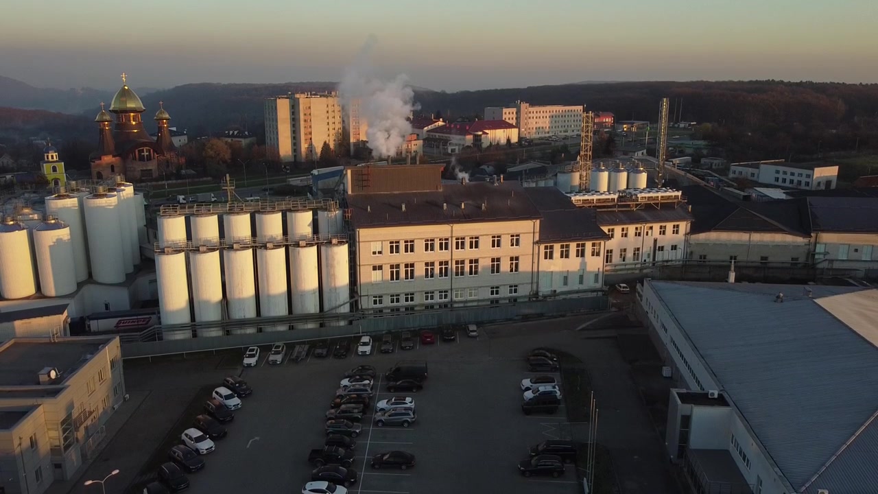 Vista aerea di un drone che sorvola il birrificio, diverse file di serbatoi