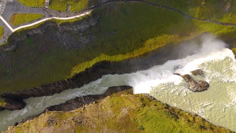Top-down-aerial-view-of-thermal-river-stream-in-a-canyon,-Iceland