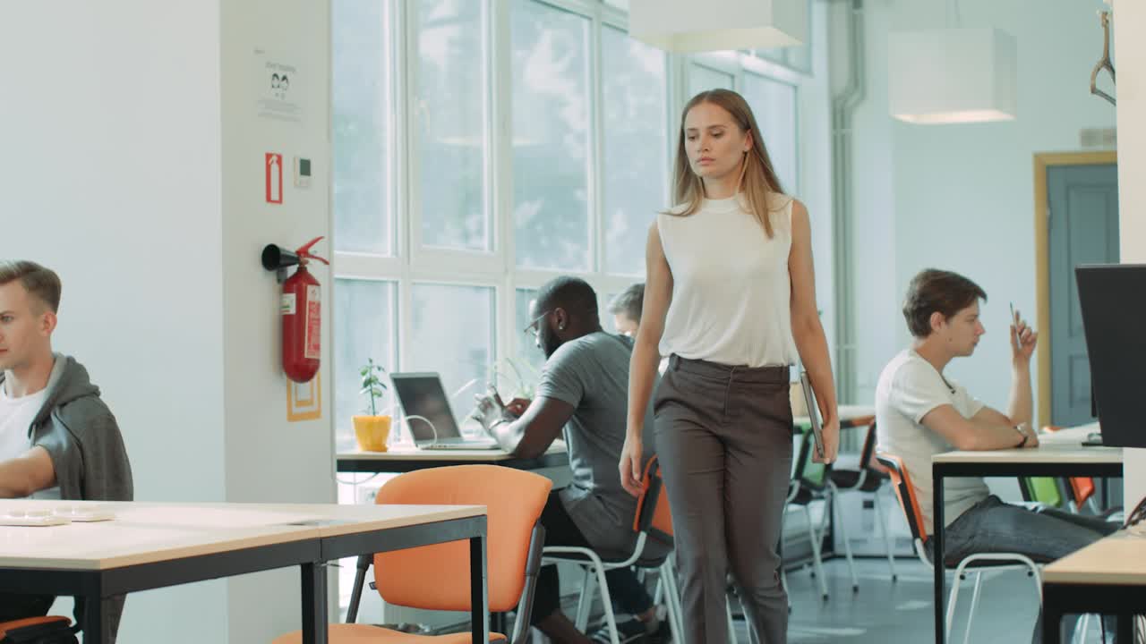 Ragazza concentrata che entra nel coworking. Primo piano di donna che intende lavorare in ufficio.