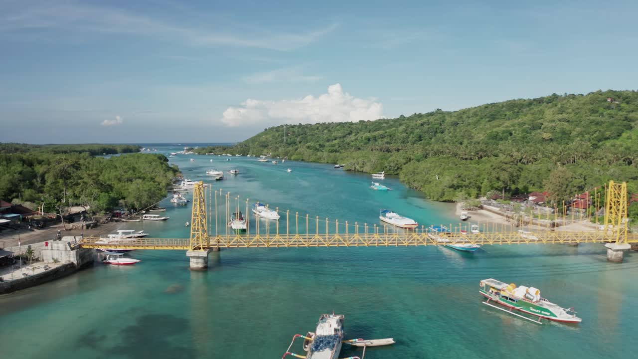 A bright, high-angle aerial drone shot capturing the famous Yellow Bridge (Jembatan Kuning) which connects the islands of Nusa Lembongan and Nusa Ceningan