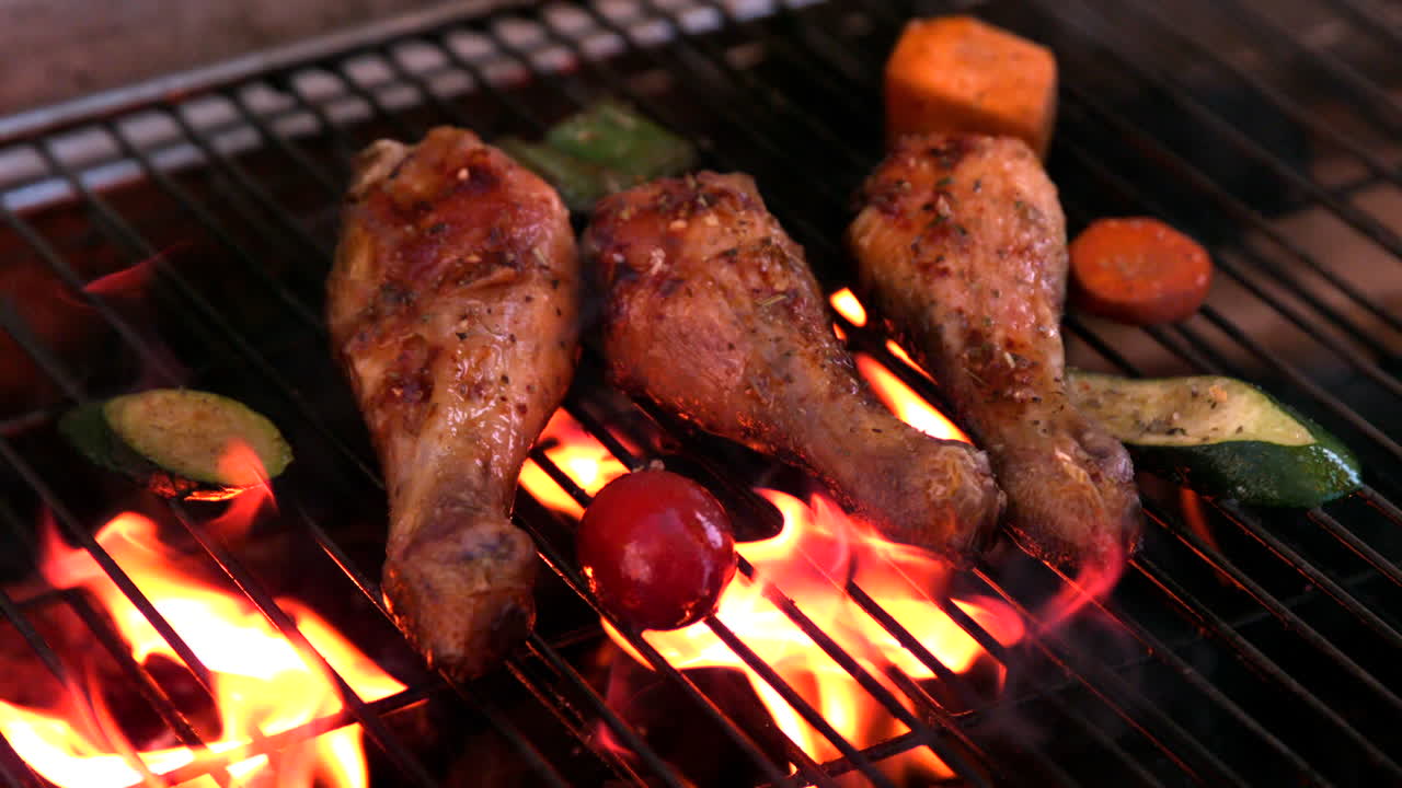 Fusi di pollo in cottura su un barbecue in fiamme