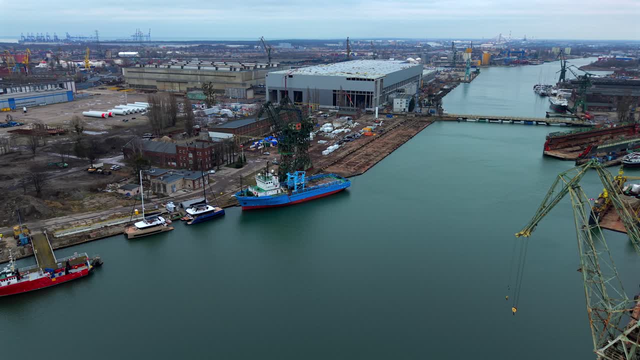 Aerial shot over Gdansk Shipyard with ships, cranes, and the Martwa Wisla river