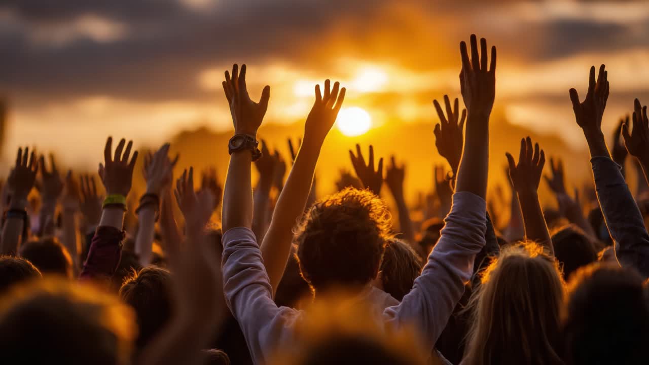 A Vibrant Crowd Celebrates Against a Stunning Sunset, Their Hands Raised in Unity and Joy, Capturing a Moment of Enthusiasm and Togetherness