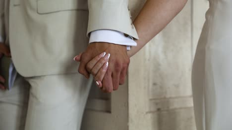 primer plano del novio y la novia abrazados y tomados de la mano el día de la boda, primer plano