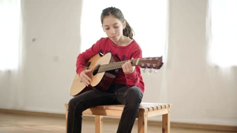una joven tocando la guitarra y cantando