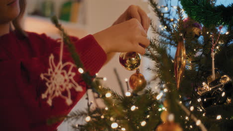 mujer atando baubles mientras decora el árbol de navidad