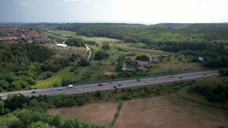 Cars-driving-on-highway-with-City-of-Gdynia-in-background-during-summer