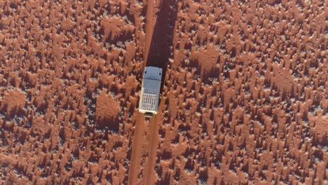 aerial view of safari vehicle driving through the famous fairy circles of namibia