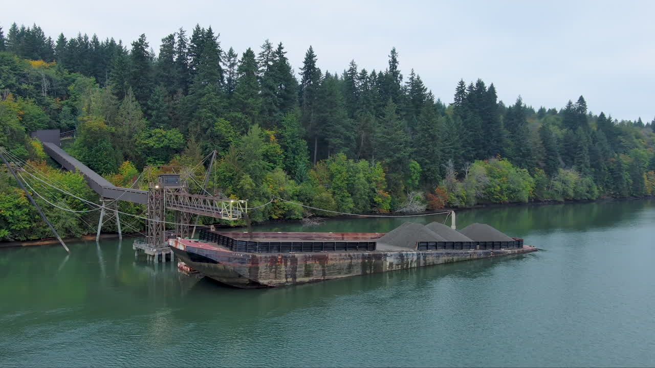 가을에 소나무 숲으로 둘러싸인 푸게트 사운드에서 비석으로 가득 찬 배의 드론 영상
