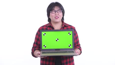 Portrait of beautiful overweight Asian woman holding laptop with chroma key copy space isolated against white studio background