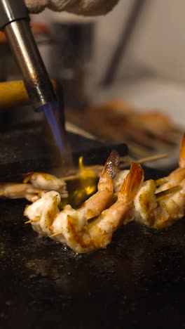 cooking shrimp skewers with a blowtorch