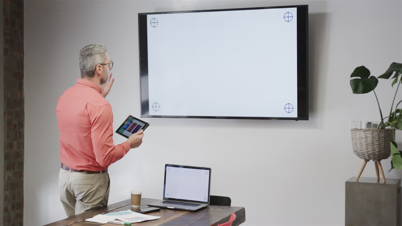 카우카시안 캐주얼 사업가 태블릿과 모니터를 사용하여 비디오 통화를 하고 복사 공간, 느린 동작