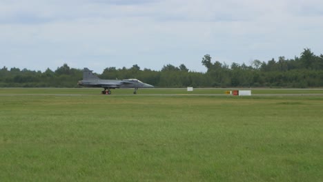 saab jas-39 gripen fighter jet taxing on runway, baltic international airshow, handheld 4k shot