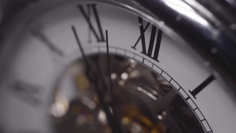 seconds hand crossing a number on a shiny chrome watch - macro shot