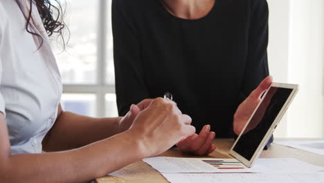 primer plano de mujeres de negocios que usan tableta digital en una reunión