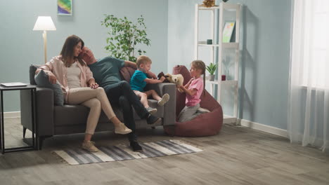 man and woman are in room with children, children happily play with toys