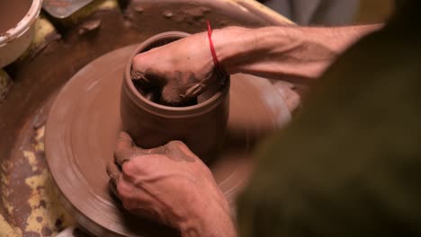 primer plano de un hombre alfarero haciendo un cuenco de arcilla en una rueda de alfarero de arcilla