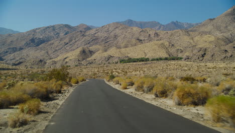 empty road in palm springs with the rugged san jacinto mountains rising behind them in california