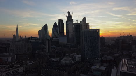 Golden-sunrise-over-London,-UK-showing-Shard-and-Gherkin-high-rises