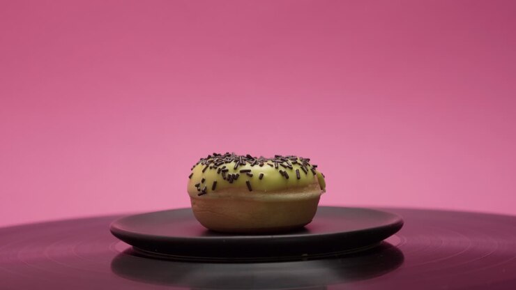 Delicious American donut with yellow sweet topping and choco crumbs