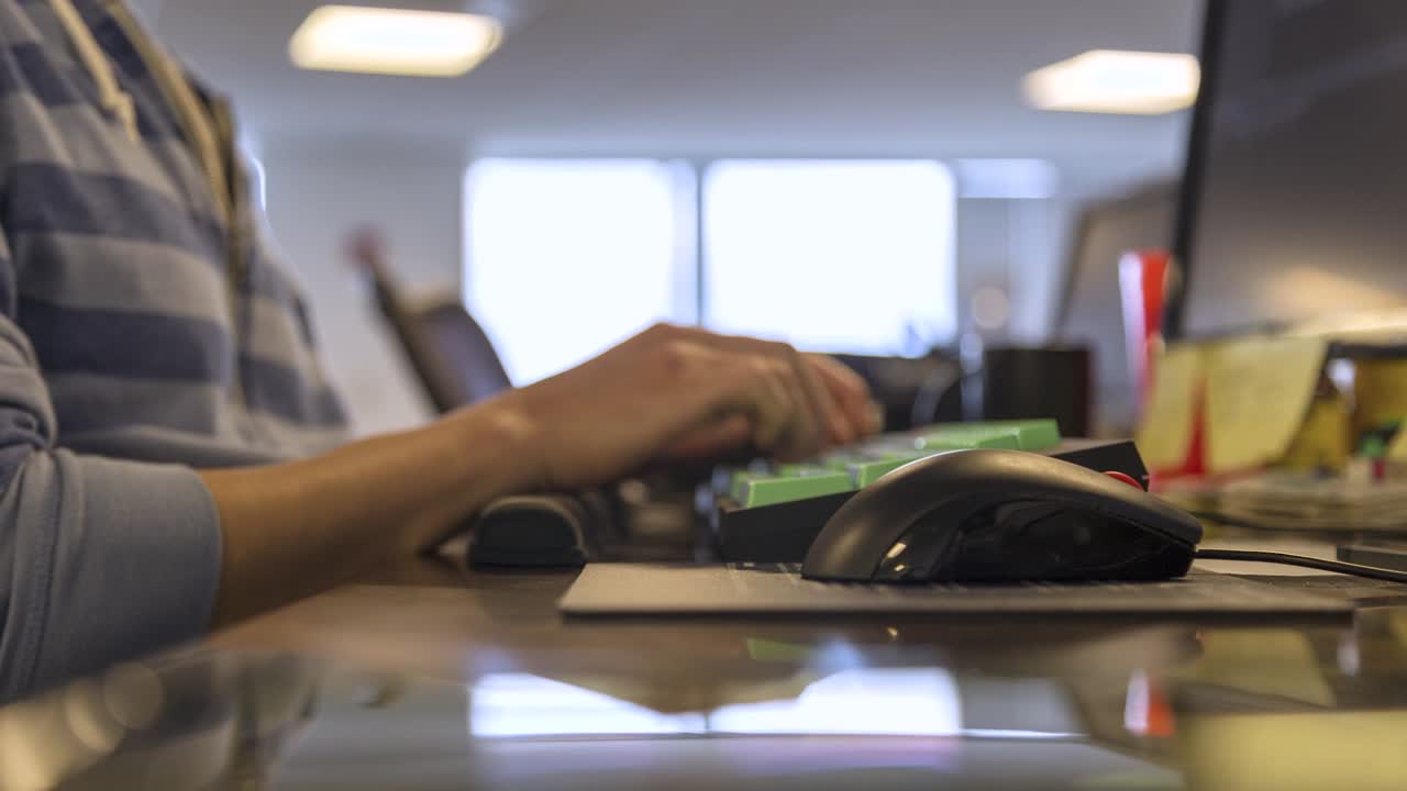 사무실의 컴퓨터 스테이션에서 일하는 남자의 손의 시간경과