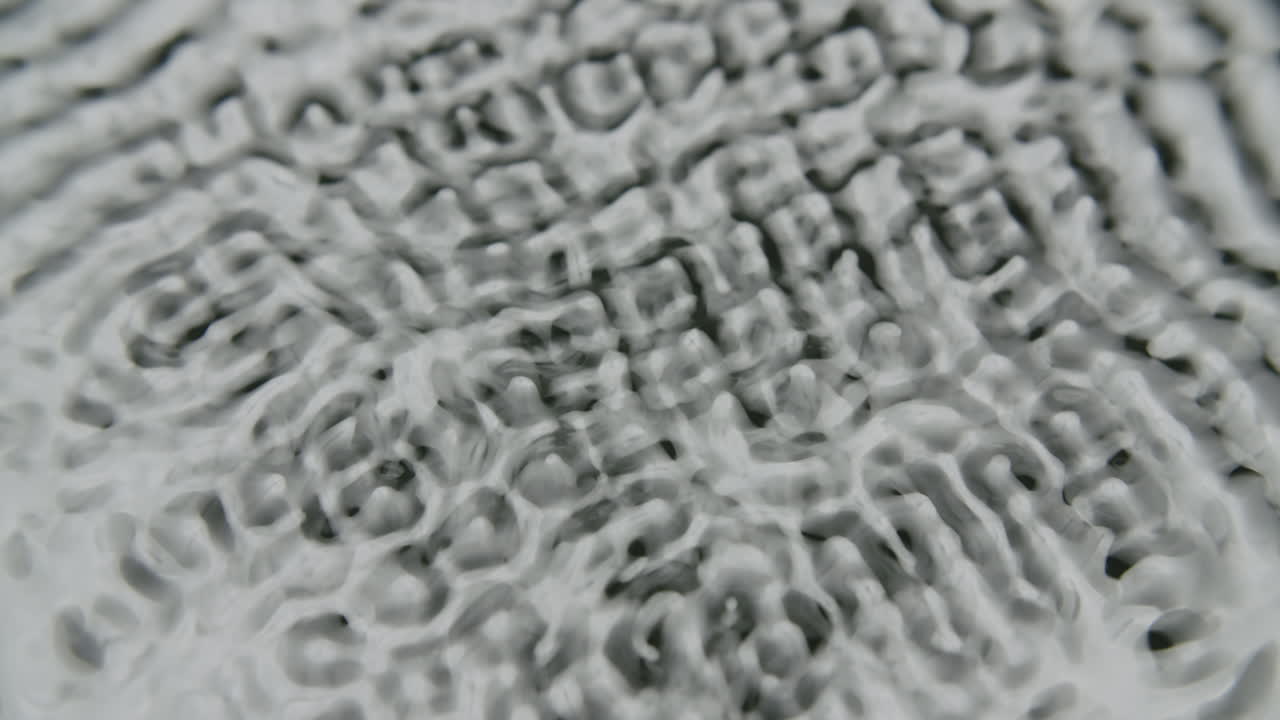 어둡고 불투명한 액체가 진동하기 시작하고 다른 구조와 파동을 형성합니다.