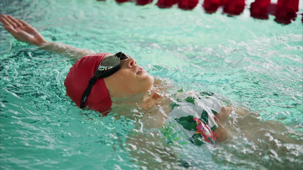 Captivating Moments of a Young Swimmer Mastering the Art of Backstroke Technique in Crystal Clear Water During a Competitive Training Session