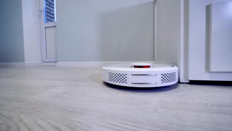 a tracking shot of a round robotic vacuum cleaner.