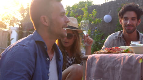 Friends-Blowing-Bubbles-During-Picnic-In-Garden