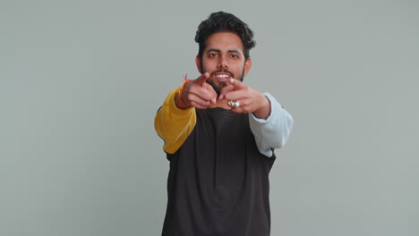 indian man smiling excitedly, pointing to camera, choosing lucky happy winner, indicating, hey you