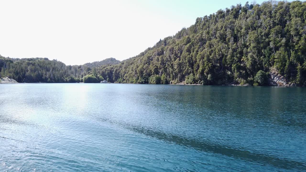 Steep dense forest lines the shore of Nahuel Huapi Lake in Patagonia