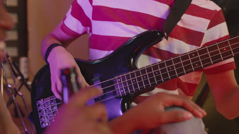 cerca de un chico irreconocible tocando la guitarra mientras una chica lo escucha y bebe cerveza durante un ensayo en el estudio de grabación 1