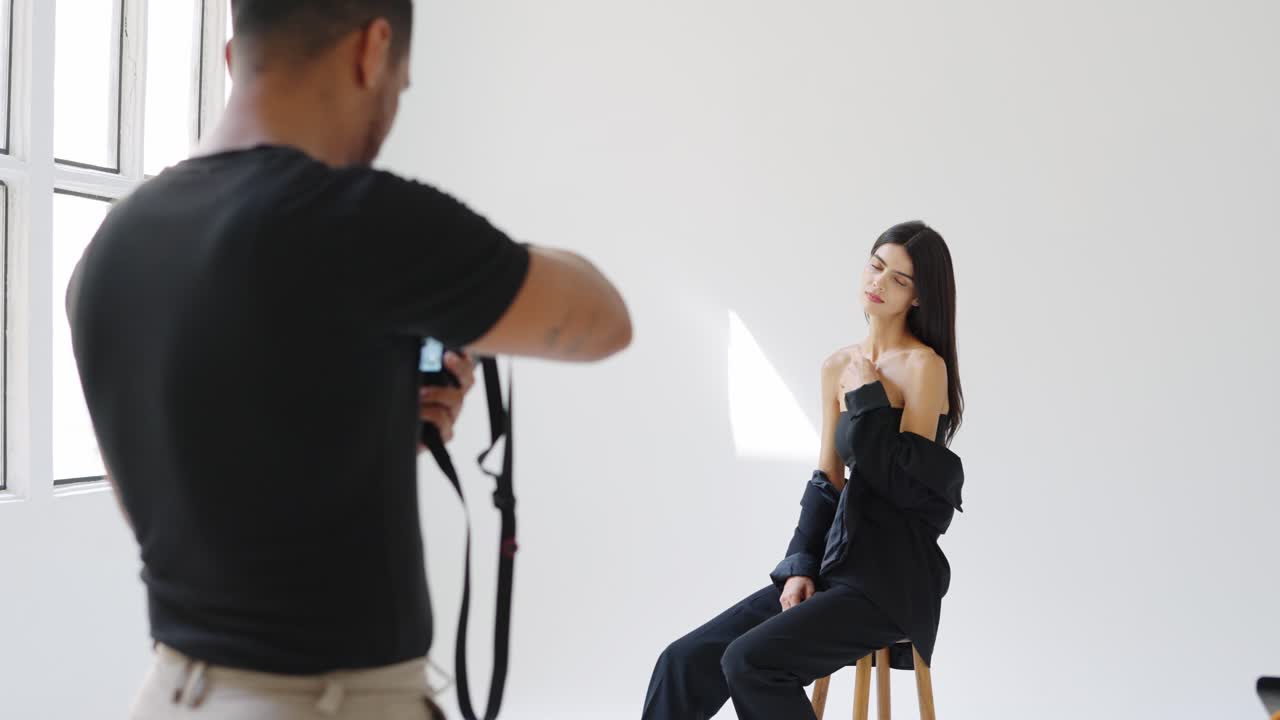 A fashion photoshoot in a studio with a model and photographer
