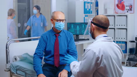 senior patient wearing mask at doctor appointment