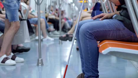 cerca de las piernas y el palo del hombre ciego en el vagón del metro- cámara lenta