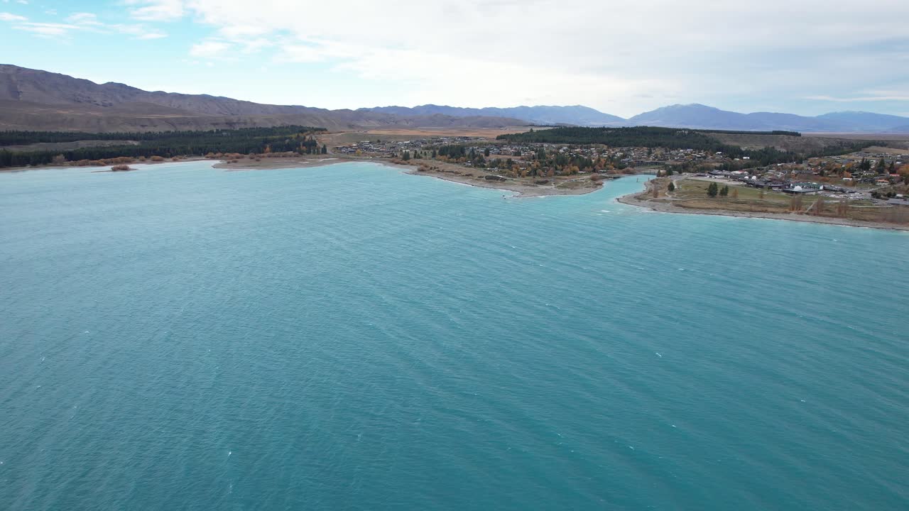 Vibrant Turquoise Lake In Township Of Lake Tekapo In South Island, New Zealand. wide aerial shot