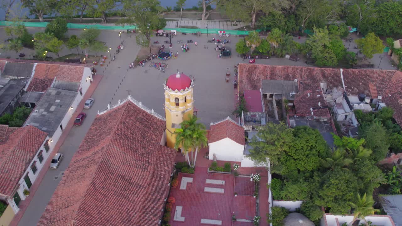 Soaring above the Magdalena River, witness the charm of Mompox's colonial architecture. Roll right with yaw left and gimbal move.