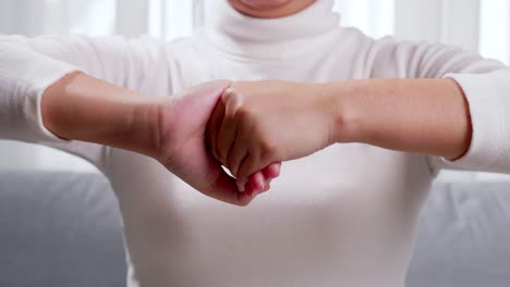 Young-woman-performing-self-hand-massage-during-break-in-office