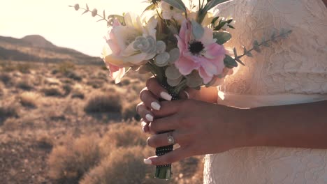 Slow-motion-pan-across-bride-holding-bouquet-during-sunset