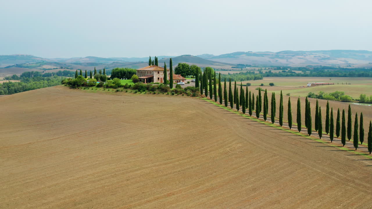 Idyllic house in the hills of Tuscany with driveway lined with cypress trees