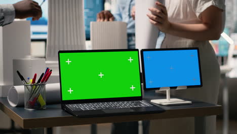 laptop and tablet with green and blue screens in office setting