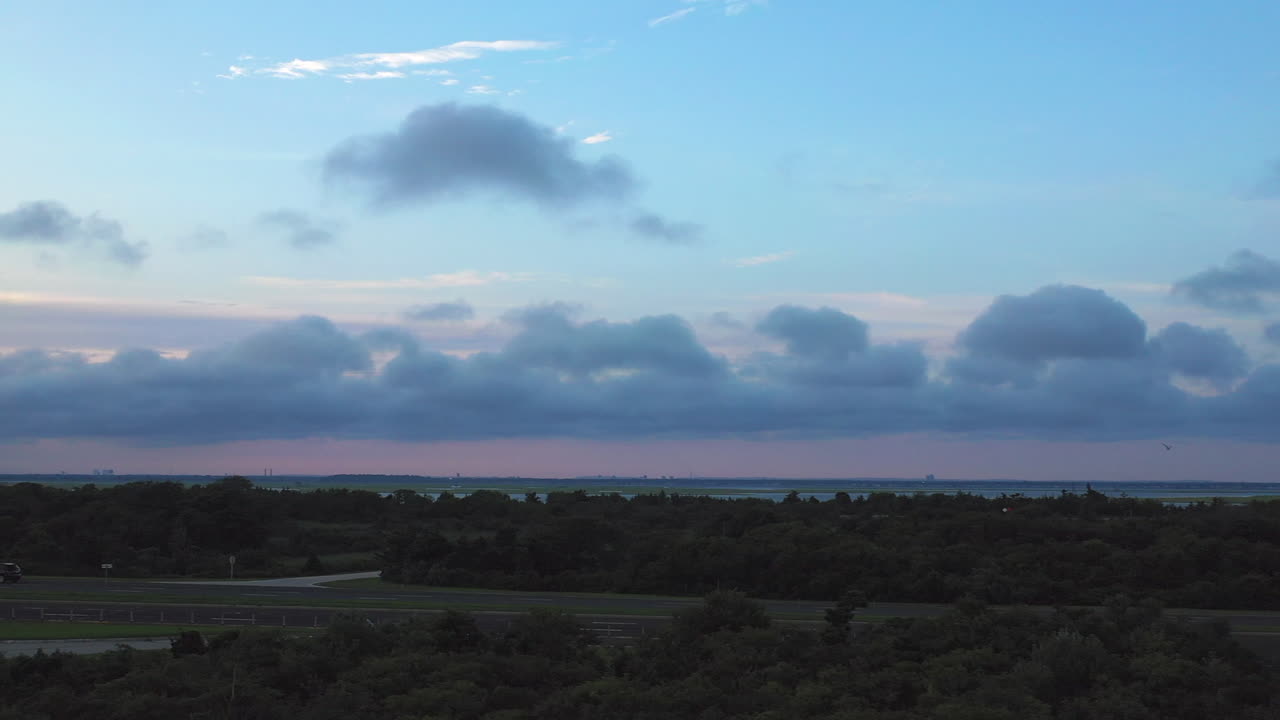 pan a la izquierda a baja altura con horizonte con rosa - cielo azul del atardecer a la vista cerca de jones beach en nueva york frente a la bahía