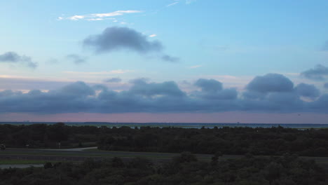 pan-left-at-a-low-height-with-horizon-with-pink---blue-sunset-sky-in-view-near-Jones-Beach-in-New-York-facing-the-bay