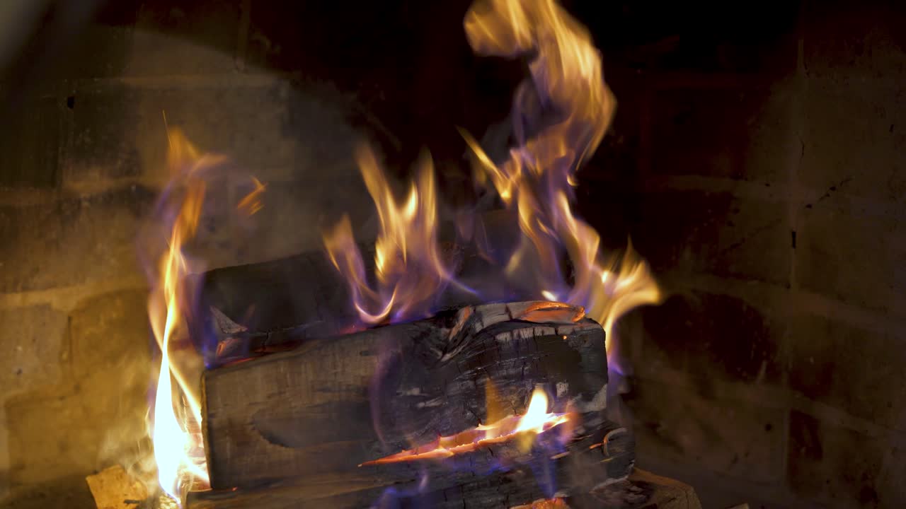 Cozy fireplace at home. Wood burning in the fireplace. Christmas tree near the fireplace in winter. Comfortable atmosphere on winter holidays