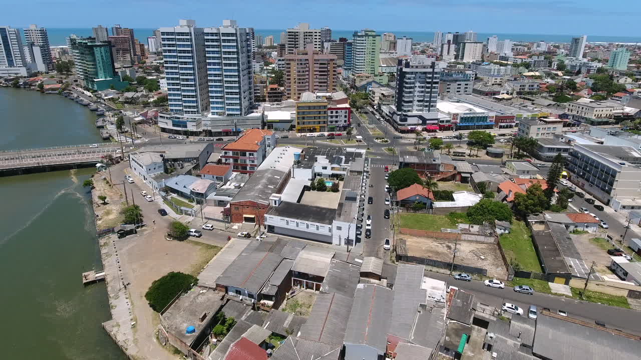 Vista aerea del centro di Tramandaí dal lato del fiume con edifici di media altezza e paesaggio urbano costiero nel Brasile meridionale