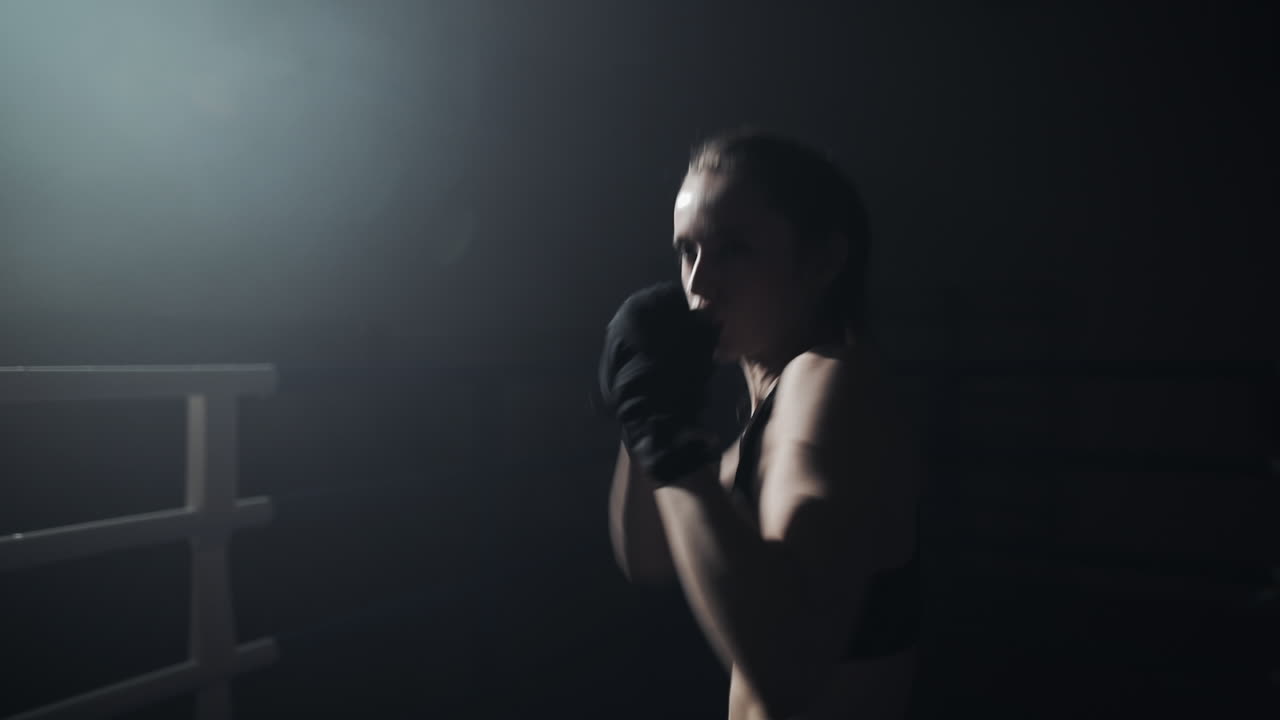 Donna che fa shadow boxing sotto un riflettore